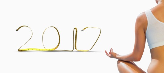 Composite image of fit woman sitting in lotus pose 