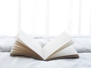 Fresh morning read book on the bed, soft focus.