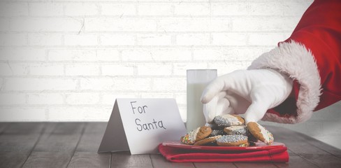 Composite image of close-up of santa claus taking cookies