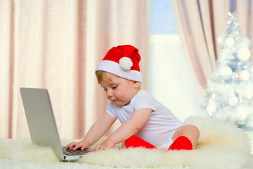 Cute santa baby with laptop