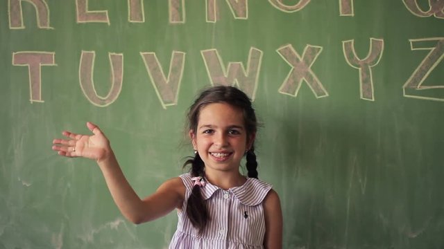 Portrait of a Smiling Caucasian Schoolgirl Saying Hello
