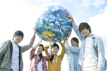 地球のボールを持つ若者たち