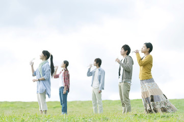 草原で水を飲む若者たち