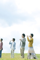 草原で水を飲む若者たち