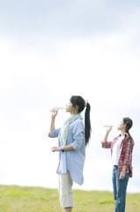 草原で水を飲む若者たち