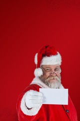 Composite image of close-up of santa claus holding blank paper