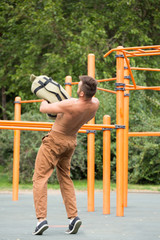 Obraz premium Man Performing Bag Squat Exercise Outdoor