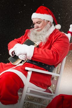 Composite image of santa claus holding bible while relaxing on c