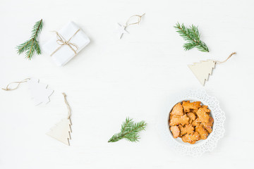 Fototapeta na wymiar Christmas workspace. Gift, fir branches, christmas cookies. Flat lay, top view