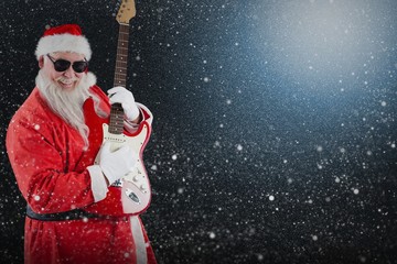 Composite image of smiling santa claus playing a guitar