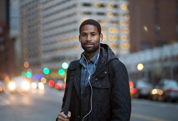 Portrait of African American man listening to music in the city