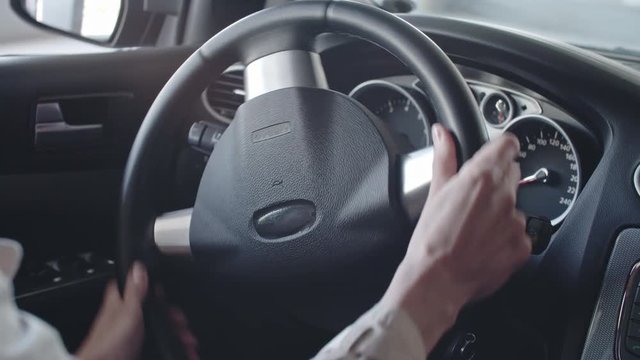 Hands of female driver steering wheel of car