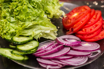 Fresh sliced vegetables. Tomato, cucumber, onion and lettuce