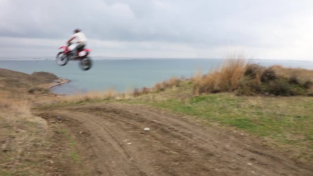 Motorcyclist at high speed jumping over the ravine

