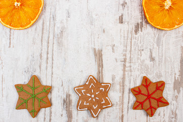 Decorated gingerbread and dried orange on old wooden background, christmas decoration