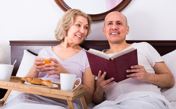 Mature couple having breakfast in bed.