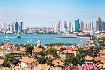 Qingdao Bay with Zhanqiao Pier seen from the hill of XiaoYuShan Park, Qingdao. Zhanqiao is the famous pavilion displayed on the bottles of Qingdao beer - obrazy, fototapety, plakaty