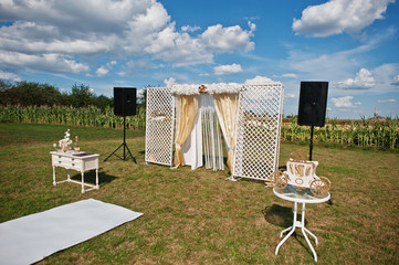 Wedding arch, white carpet with small table on white and golden