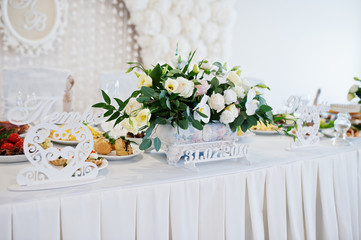 Flowers on wedding table of newlywed. Decorative hearts and sign