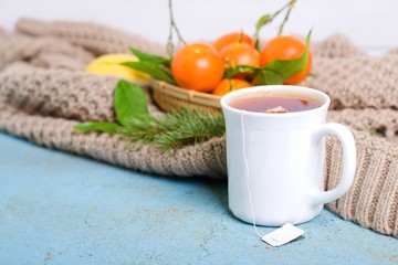 Traditional winter beverage tea tangerine and lemon. Christmas drink. Gray background with knitted scarf