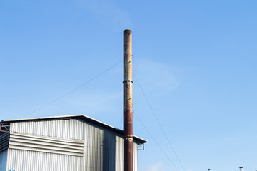 Bio power plant with storage of wooden fuel against blue sky