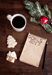 notebook and goals for new year wooden background top view