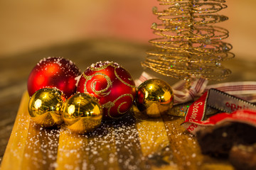 Lovely close up image of Christmas cookies on a wooden chopping board with some scented candles and a glass of whiskey / coffee and some cinnamon sticks.