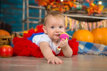 Fototapeta na wymiar Happy one year old baby girl in autumn interior