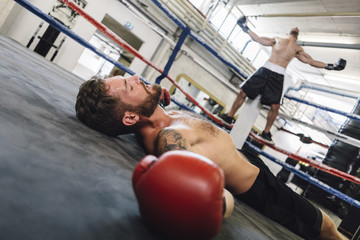 Knocked out boxer lying in boxing ring