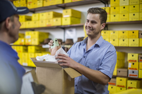 Man in warehouse checking delivered cardboard box