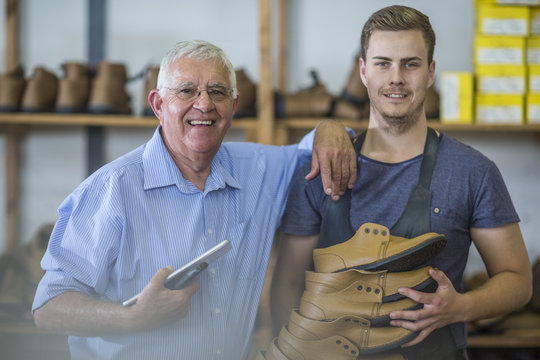Portrait of smiling senior man and young man holding shoes - Powered by Adobe