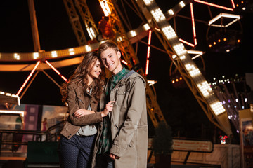 Fototapeta na wymiar Portrait of joyful young couple in amusement park