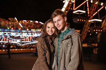 Fototapeta na wymiar Young smiling couple in amusement park