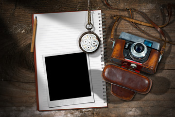 Old camera, empty notebook, pencil, broken pocket watch and instant photo frame