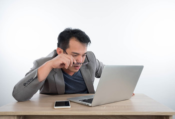 young businessman Stressful jobs using a laptop sitting thinking