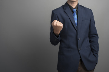 Close up of businessman in blue suit Fighting on gray background