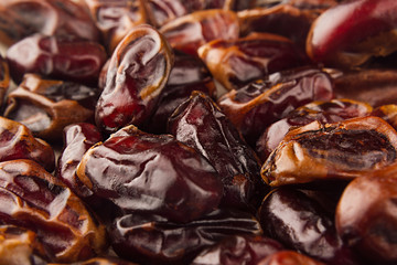 Date fruit closeup background. Heap of dried shiny brown red date fruit. Top view.