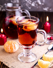 Mulled wine in a glass on wooden background