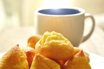 vanilla cream puff on dish and coffee cup