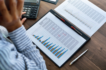 Financial paper charts and graphs on the table.