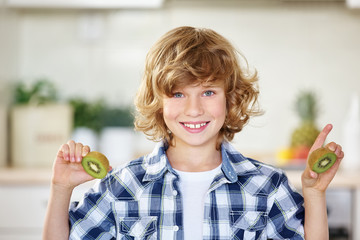 Happy boy holding kiwi