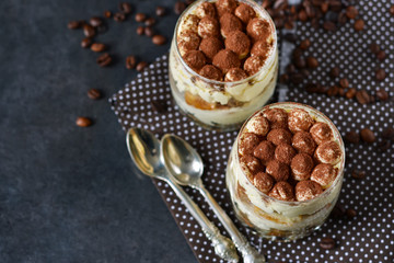 Classic tiramisu in a glass jar on black background