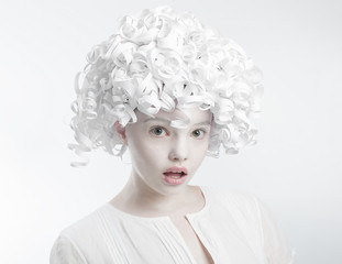 Portrait of a surprised girl with curly hair paper..