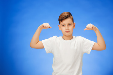 Beauty smiling sport child boy showing his biceps