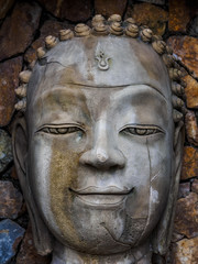 Fototapeta na wymiar Sandstone face of Buddha in the niche of the wall
