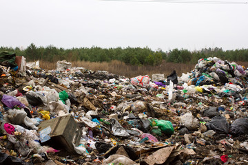 Pile of plastic bags and other refined petroleum products dumped in landfill. Garbage heap gives...