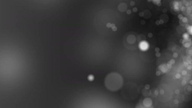 Dark gray motion background. Abstract glowing bokeh circles or sparks. 4K seamless loop animation