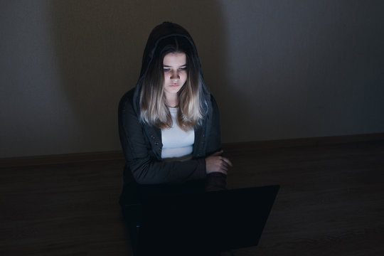 sad and scared female teenager with tablet computer and laptop suffering cyberbullying and harassment being online abused by stalker or gossip feeling desperate and humiliated in cyber bullying