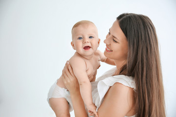 Mother holding little baby indoors