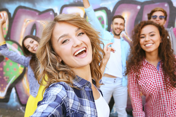 Happy friends taking selfie on street